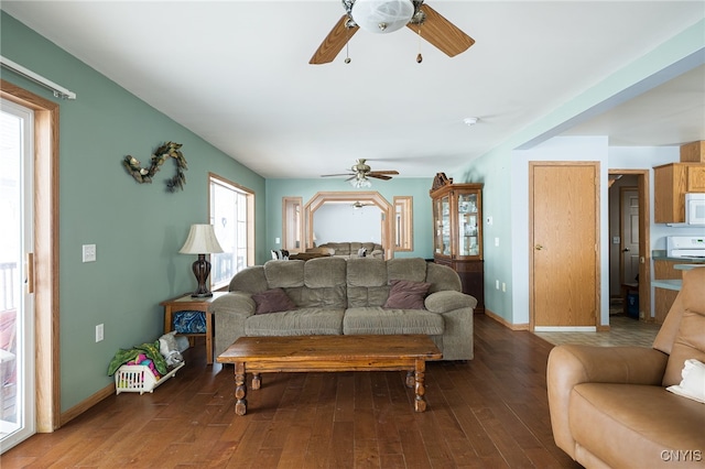 living room with ceiling fan and dark hardwood / wood-style flooring