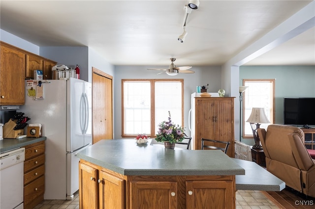 kitchen with white appliances, a center island, and ceiling fan