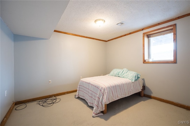 carpeted bedroom featuring ornamental molding and a textured ceiling