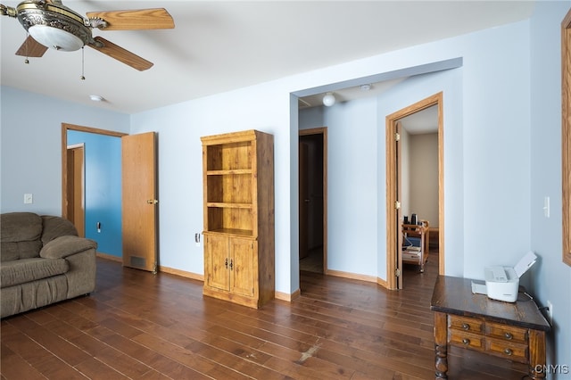 living room with dark wood-type flooring and ceiling fan