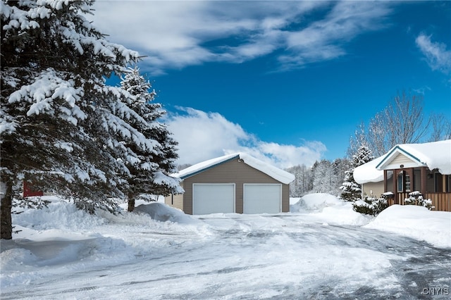 snow covered garage featuring a porch