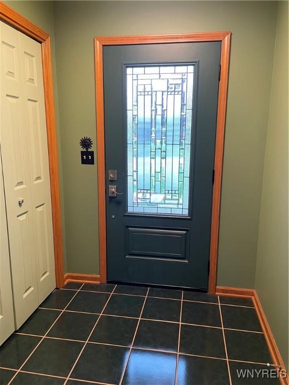 doorway to outside with dark tile patterned floors