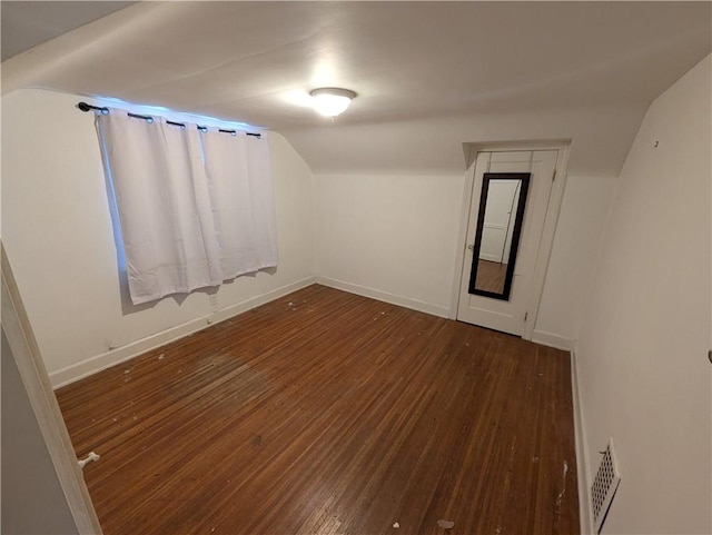 spare room with dark hardwood / wood-style floors and vaulted ceiling