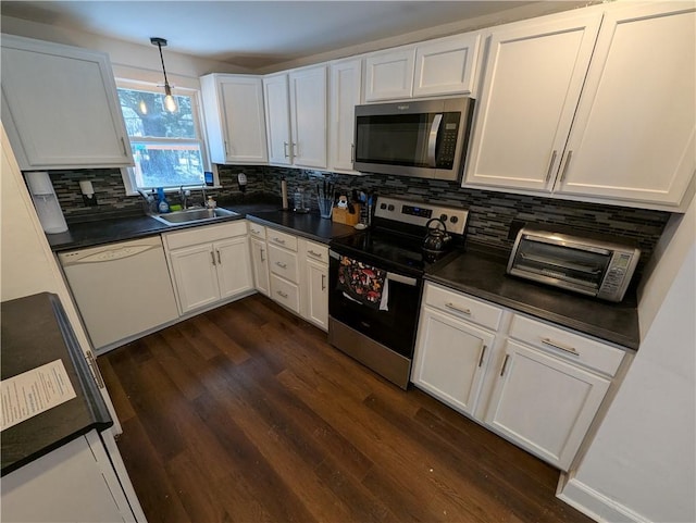 kitchen with sink, appliances with stainless steel finishes, hanging light fixtures, white cabinets, and dark hardwood / wood-style flooring