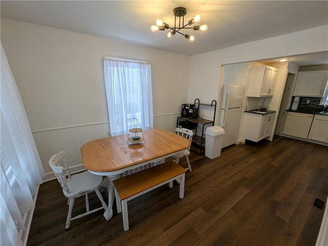 dining area featuring dark hardwood / wood-style floors and a notable chandelier