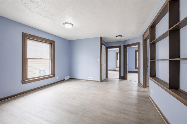 spare room with hardwood / wood-style floors and a textured ceiling