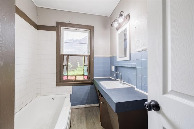 bathroom featuring tile walls, vanity, a bathtub, and hardwood / wood-style flooring