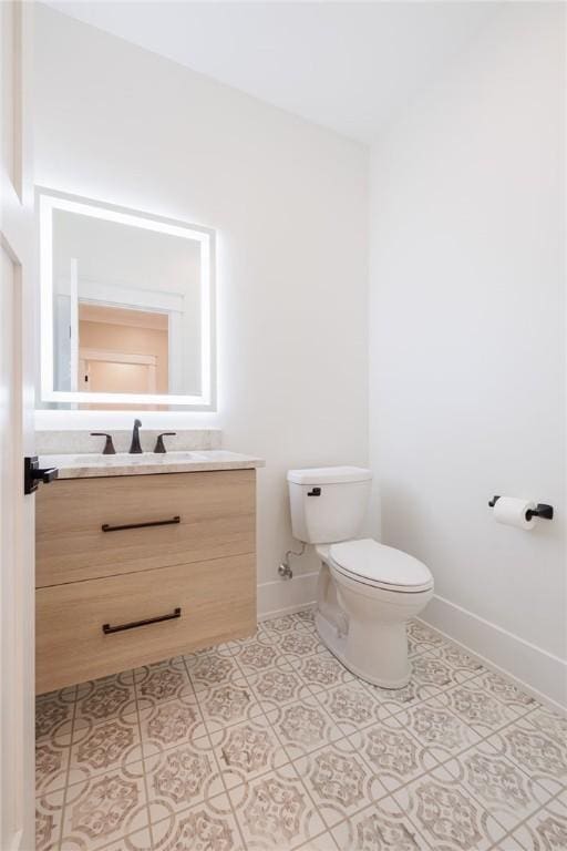 bathroom featuring tile patterned flooring, vanity, and toilet