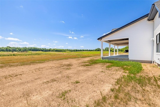 view of yard featuring a rural view and a patio