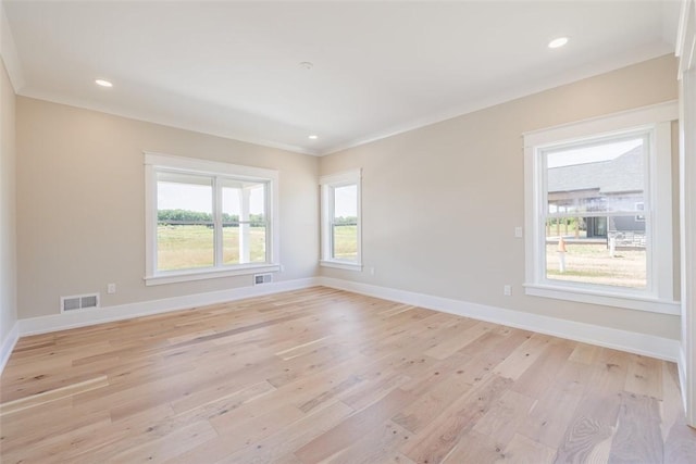 empty room with crown molding and light hardwood / wood-style flooring