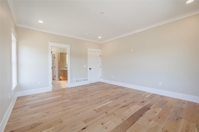 unfurnished room featuring ornamental molding and light hardwood / wood-style flooring