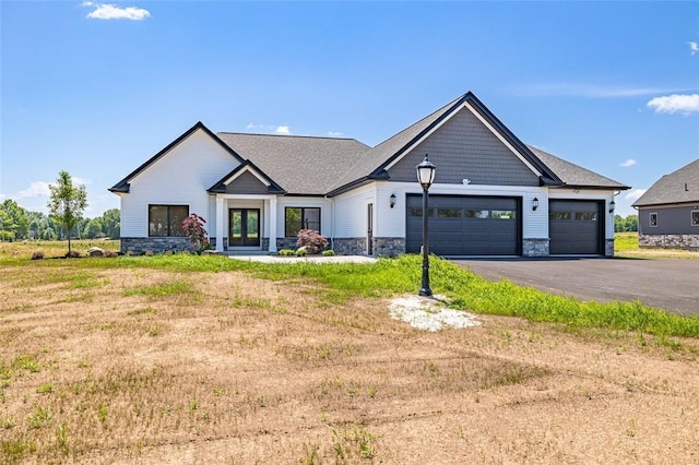 modern inspired farmhouse with a garage, a front yard, and french doors