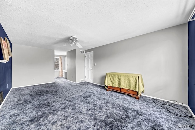 unfurnished bedroom with ceiling fan, carpet, and a textured ceiling