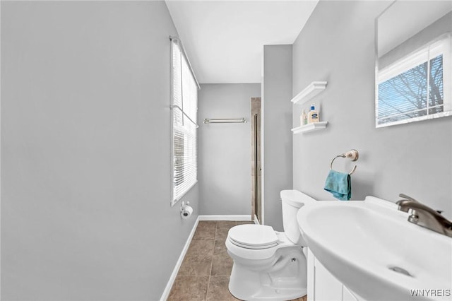 bathroom featuring toilet, tile patterned flooring, and sink