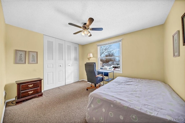 bedroom featuring ceiling fan, light colored carpet, a closet, and a textured ceiling