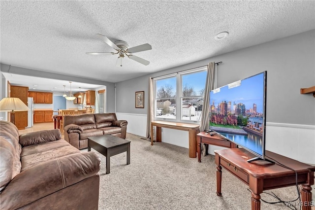 living room featuring light carpet, a textured ceiling, and ceiling fan