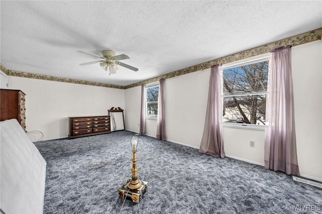 unfurnished bedroom featuring ceiling fan, a textured ceiling, and carpet