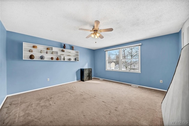 interior space featuring ceiling fan, carpet, and a textured ceiling