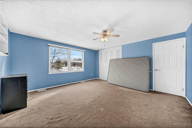 unfurnished bedroom featuring ceiling fan, a closet, carpet, and a textured ceiling