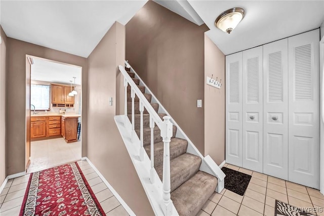 stairway featuring sink and tile patterned floors