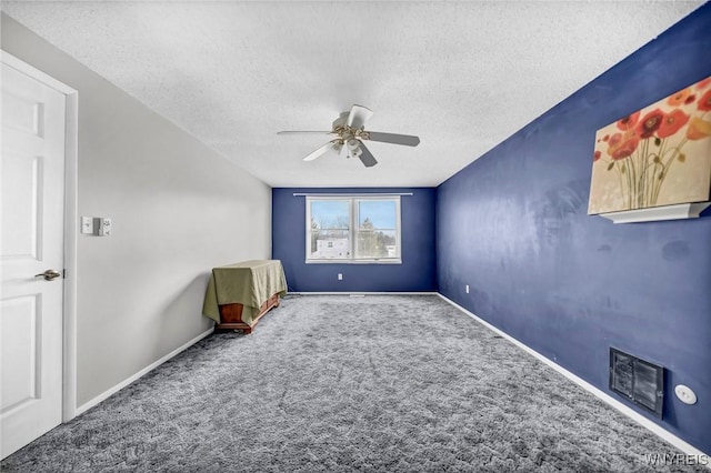 unfurnished room with ceiling fan, a textured ceiling, and carpet flooring