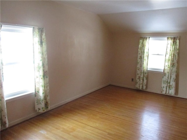 unfurnished room with lofted ceiling and light hardwood / wood-style floors