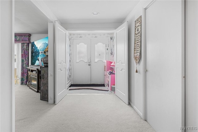 corridor featuring french doors and light colored carpet