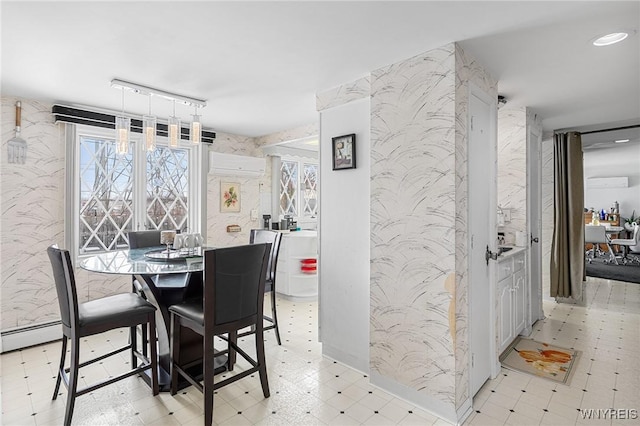 dining room featuring rail lighting and an AC wall unit