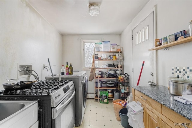 kitchen with stainless steel gas stove and washing machine and dryer