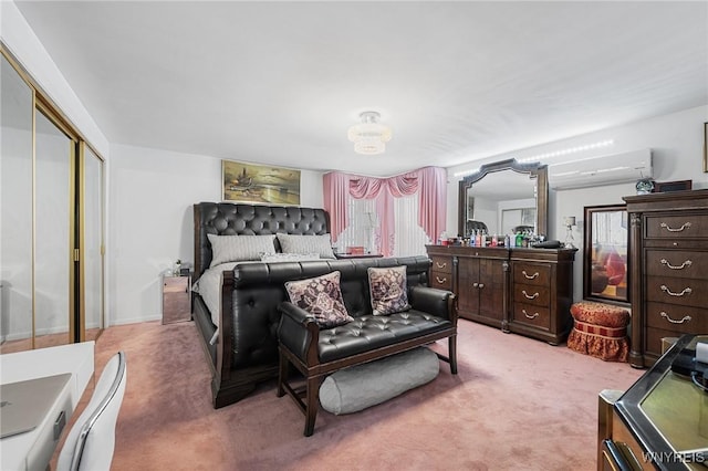 bedroom featuring an AC wall unit, light carpet, and a closet