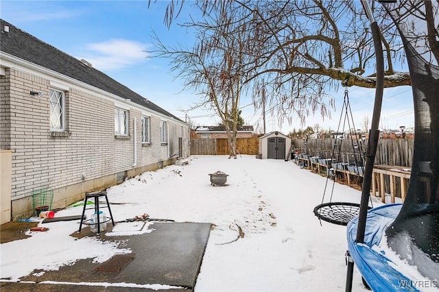 snowy yard with a storage unit