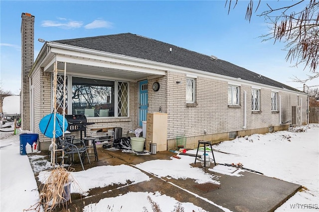 view of snow covered rear of property