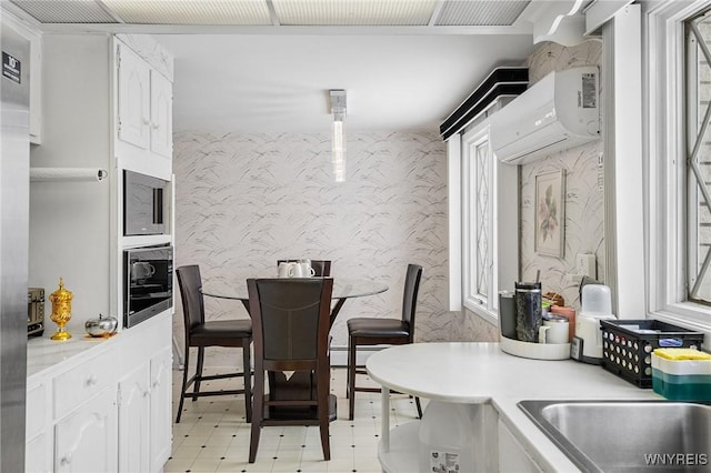 kitchen with white cabinetry, beverage cooler, and an AC wall unit