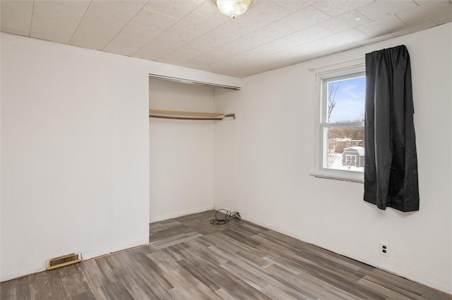 unfurnished bedroom featuring hardwood / wood-style floors and a closet