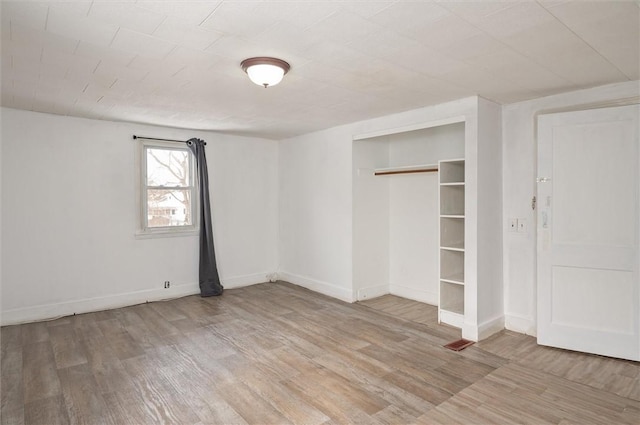 unfurnished bedroom featuring wood-type flooring and a closet