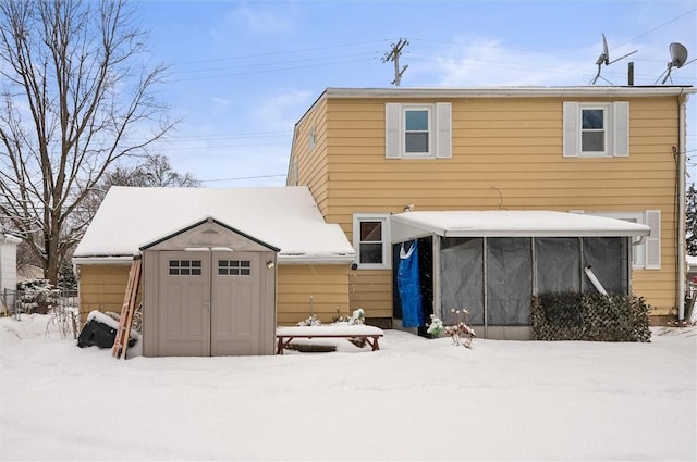 snow covered property featuring a storage shed