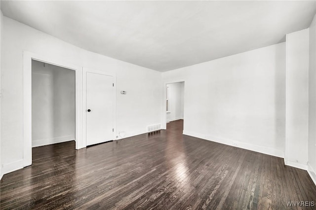 empty room with dark hardwood / wood-style flooring