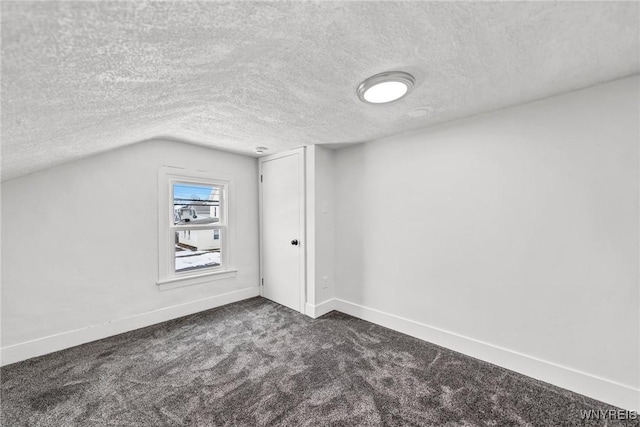 bonus room with vaulted ceiling, a textured ceiling, and dark colored carpet