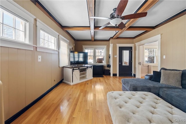 living room with beamed ceiling, ceiling fan, coffered ceiling, and light hardwood / wood-style floors