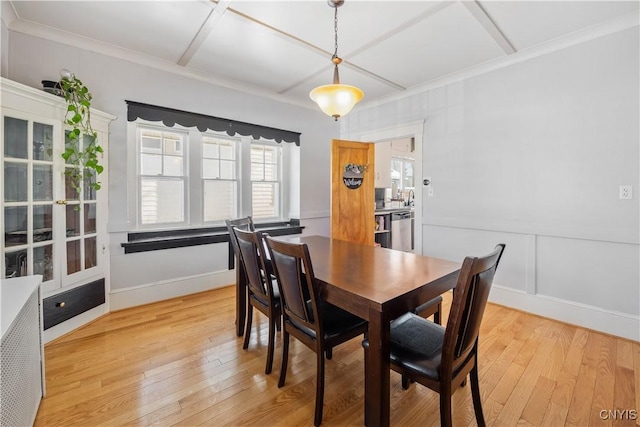 dining room featuring coffered ceiling, crown molding, and light hardwood / wood-style flooring