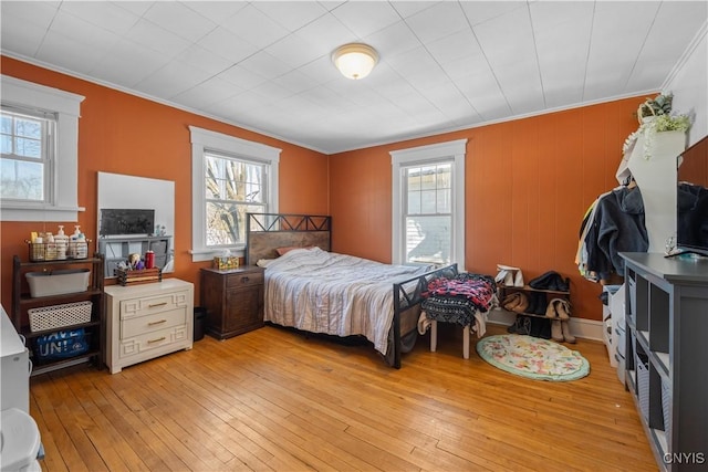 bedroom featuring ornamental molding and light hardwood / wood-style flooring