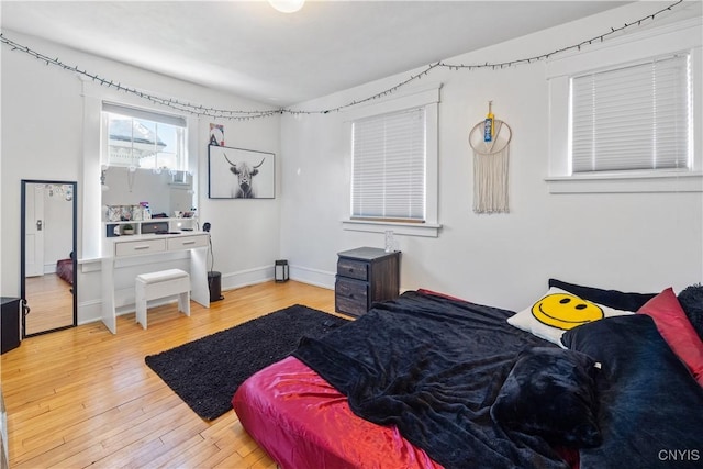 bedroom with lofted ceiling and light hardwood / wood-style flooring