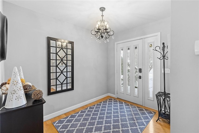 foyer entrance with a chandelier and light hardwood / wood-style flooring