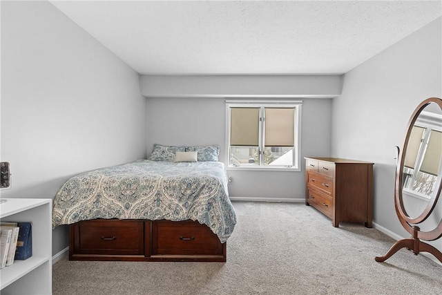 bedroom featuring light colored carpet and a textured ceiling