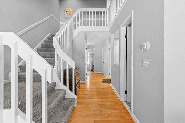 foyer featuring wood-type flooring and a towering ceiling