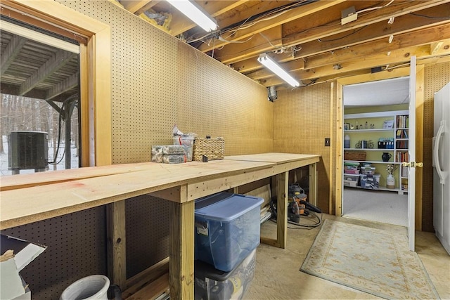 basement featuring a workshop area and refrigerator