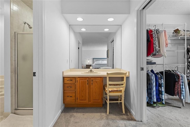 bathroom with vanity and a shower with door