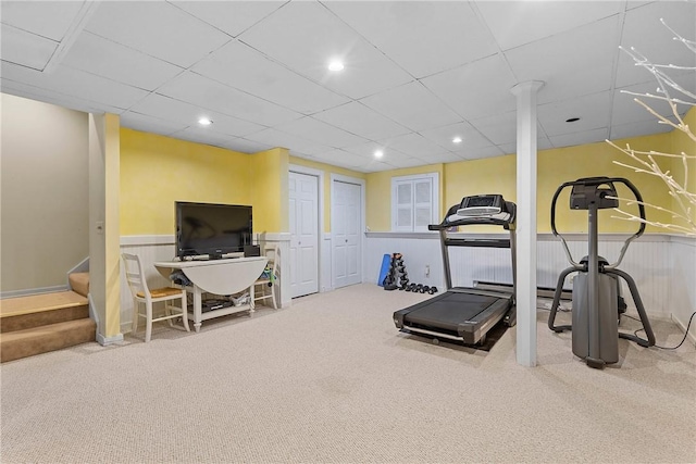 workout area featuring carpet flooring and a paneled ceiling