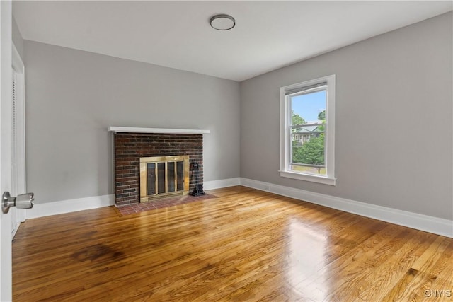 unfurnished living room featuring a fireplace and light hardwood / wood-style floors