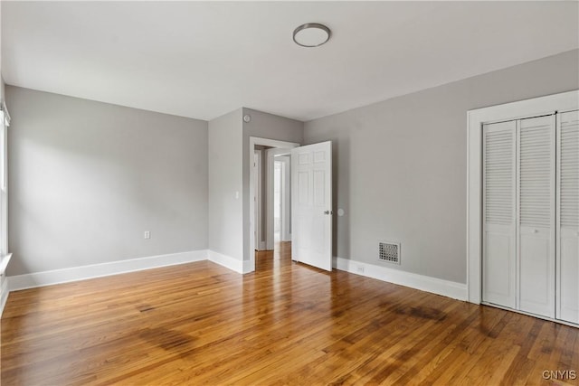 unfurnished bedroom featuring hardwood / wood-style flooring and a closet